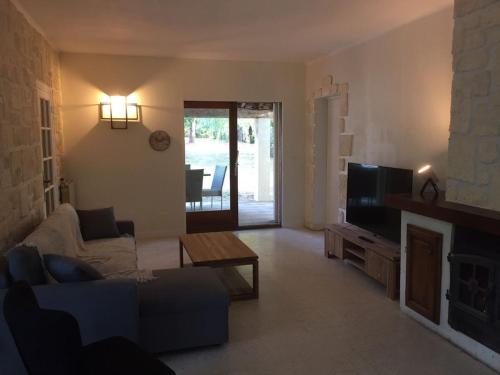 un salon avec un canapé et une télévision dans l'établissement les papillons, à Ruoms