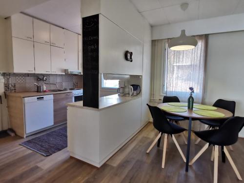 a kitchen and dining room with a table and chairs at Vuori Camp by Saimaa in Vuoriniemi