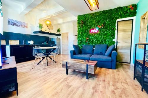 - un salon avec un canapé bleu et un mur vert dans l'établissement Jungle (Play) Room, au Muy