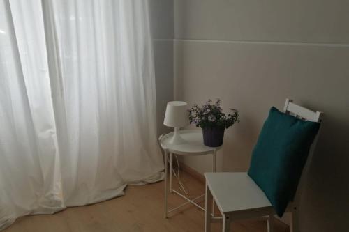 um quarto com uma mesa, uma cadeira e um candeeiro em Arina Home -Aeroporto Fontanarossa- em Catânia