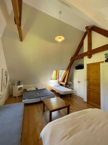 une chambre mansardée avec deux lits et une table dans l'établissement Chez Baptistète, à Labastide