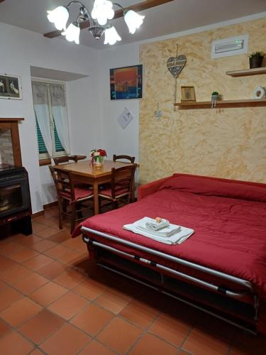 sypialnia z czerwonym łóżkiem i stołem ze stołem w obiekcie Appartamenti Belfiore w mieście Pitigliano