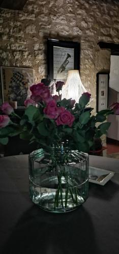 a vase of flowers sitting on a table with a lamp at Chambres d'hôtes des Princes de Bel Air in Loudun