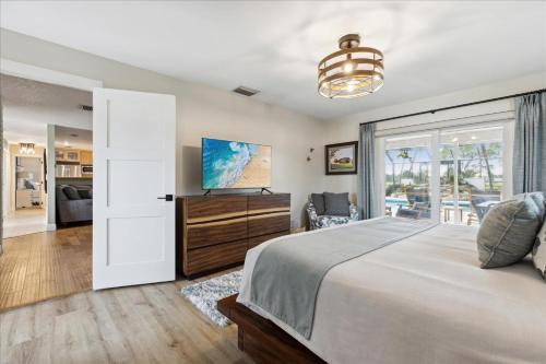 sypialnia z łóżkiem i przesuwnymi szklanymi drzwiami w obiekcie 12 Fairway Drive w mieście Cocoa Beach