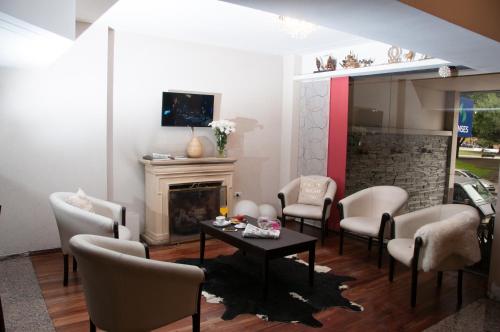 sala de estar con sillas, mesa y chimenea en Hotel del Rey en La Plata