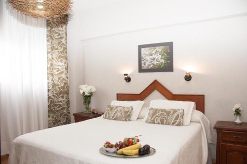Un dormitorio con una cama con un plato de fruta. en Hotel del Rey en La Plata