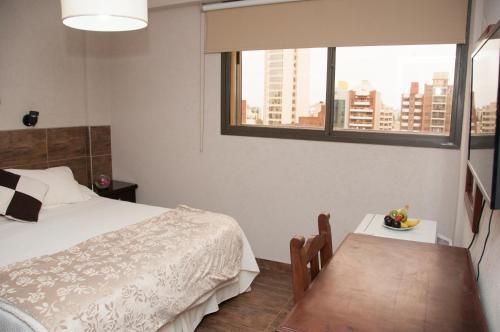 1 dormitorio con cama, mesa y ventana en Hotel del Rey en La Plata