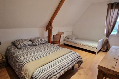 a bedroom with a bed and a bench and a table at Appartement charmant et spacieux in Auxerre
