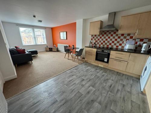 uma sala de estar com uma cozinha e uma sala de estar com um sofá em Curwen Apartment em Workington
