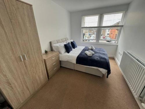 - une chambre avec un lit et une grande fenêtre dans l'établissement Curwen Apartment, à Workington