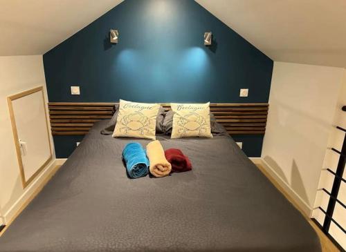 een slaapkamer met een groot bed met een blauwe muur bij Duplex 29 tout inclus in Quimper