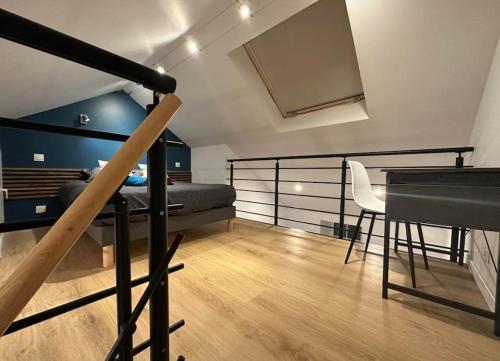 een slaapkamer met een bed, een tafel en een piano bij Duplex 29 tout inclus in Quimper