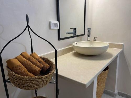 a bathroom with a sink and a basket of towels at Menzel Al karam, in Temlale