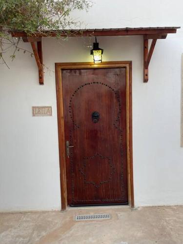 a wooden door on the side of a building at Menzel Al karam, in Temlale