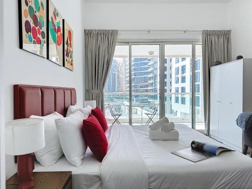 a bedroom with a large bed with red and white pillows at Key View - Marina Park in Dubai
