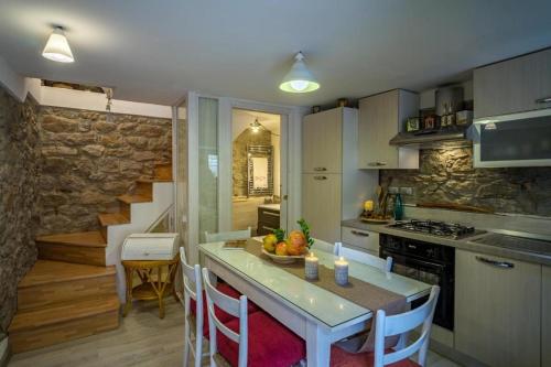 eine Küche mit einem Tisch und Stühlen sowie eine Treppe in der Unterkunft Old Noar Private Villa in Novara Sicilia