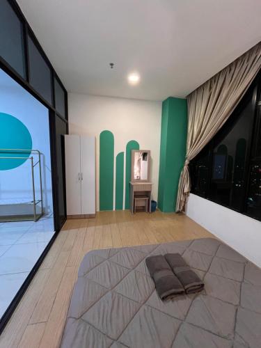 - une chambre avec un lit et un mur vert dans l'établissement FJ Haven, à Penampang