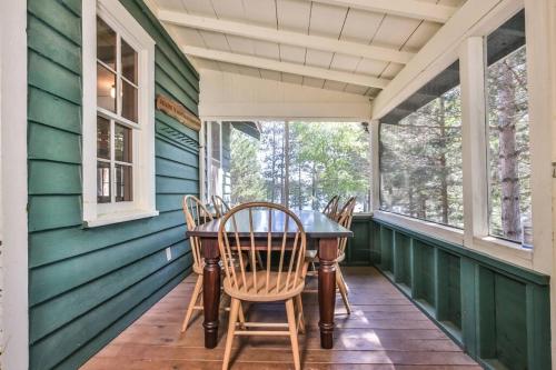 a porch with a table and chairs on it at Hearthwood Beach House - Lake Tomahawk in Minocqua