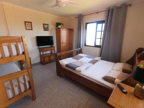 Big Room at Villa Lila في بويرتو دي لا كروث: غرفة نوم صغيرة بها سرير وتلفزيون
