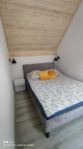 a bed with two orange pillows in a room at Nowy Domek z jacuzzi in Władysławowo