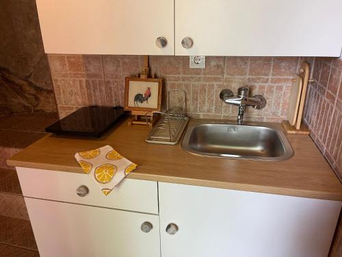 a kitchen with a sink and a wooden counter top at Cave Apartment in Virpazar