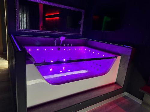 a purple bath tub with lights in a bathroom at Nubia studios & spa in Bucharest