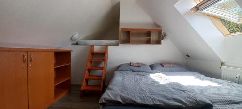 a small bedroom with a bed and a stair case at H&P Apartmán Rokytno 6 in Rokytnice nad Jizerou