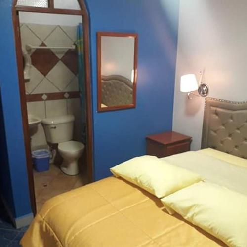 a bedroom with a bed and a toilet and a mirror at HOSPEDAJE KAROL in Ayacucho