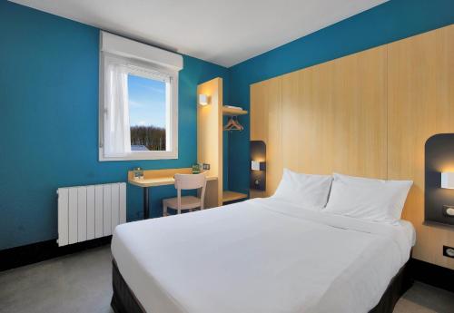 B&B HOTEL Le Tréport Friville في Friville-Escarbotin: غرفة نوم مع سرير أبيض كبير ومكتب
