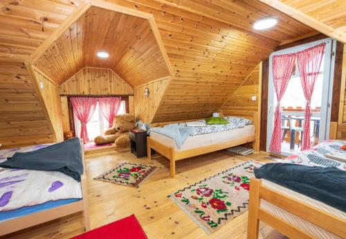 a bedroom with two beds in a wooden house at Salerno camp in Plav