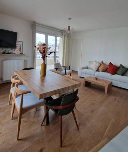 un salon avec une table et un canapé dans l'établissement Chic & Spacious 3-Bedroom with balcony, à Saint-Ouen