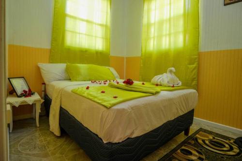 1 dormitorio con 1 cama con paredes de color verde y amarillo en River Breeze Villa, 5 minutes to beach and town, en Soufrière