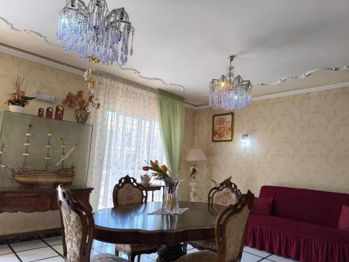 a dining room with a table and a red couch at la terrazza sull ETNA in Motta SantʼAnastasia