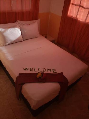 a bed with the word welcome written on it at River Breeze Villa, 5 minutes to beach and town in Soufrière