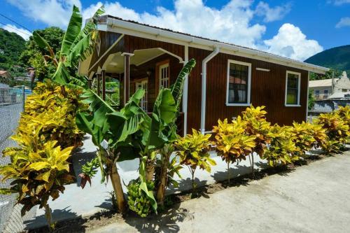 a small house with yellow flowers in front of it at River Breeze Villa, 5 minutes to beach and town in Soufrière