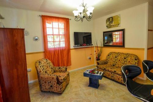 a living room with a couch and two chairs at River Breeze Villa, 5 minutes to beach and town in Soufrière