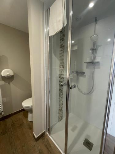 a shower with a glass door in a bathroom at Les Jardins de l'Anjou in La Pommeraye