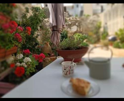 a table with a plate of food and flowers at Room in Ain Karem - A Maltese Traditional Townhouse in Mosta