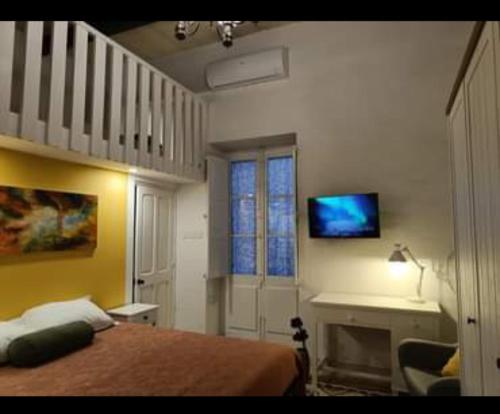 - une chambre avec un lit et une télévision murale dans l'établissement Room in Ain Karem - A Maltese Traditional Townhouse, à Mosta