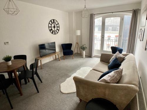 sala de estar con sofá, mesa y TV en Emily Lane Apartments en Belfast