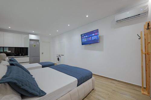 a bedroom with a bed and a tv on the wall at Cako Rooms Saranda in Sarandë