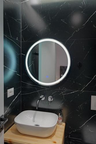 a bathroom with a sink and a mirror on the wall at Cako Rooms Saranda in Sarandë