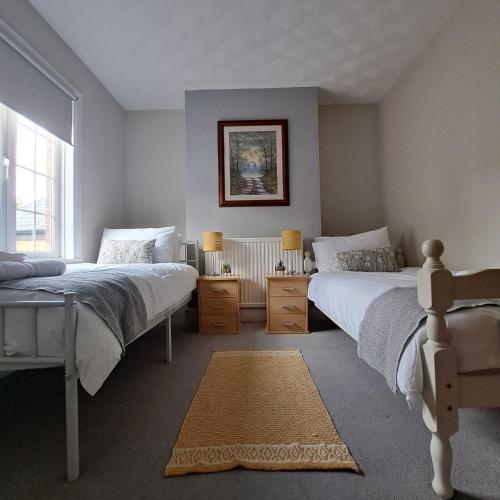 1 Schlafzimmer mit 2 Betten und einem Fenster in der Unterkunft Generous 3 bed in the heart of the village in Huntingdon