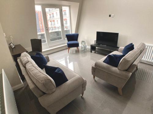a living room with two couches and a television at Cathedral Quarter Apartments in Belfast