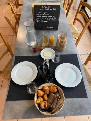 une table avec des assiettes de nourriture et un panier de pain dans l'établissement Auberge la Table du Curé, à Cucugnan