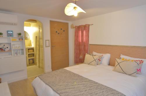 a bedroom with a large white bed in a room at Evasion in Aigues-Mortes