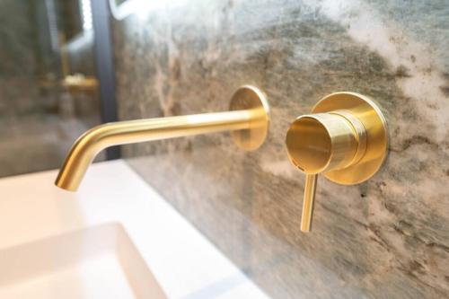 une poignée en laiton sur une porte de douche en verre dans l'établissement Magnifique appartement vue mer, piscine, garage, à Cap d'Ail