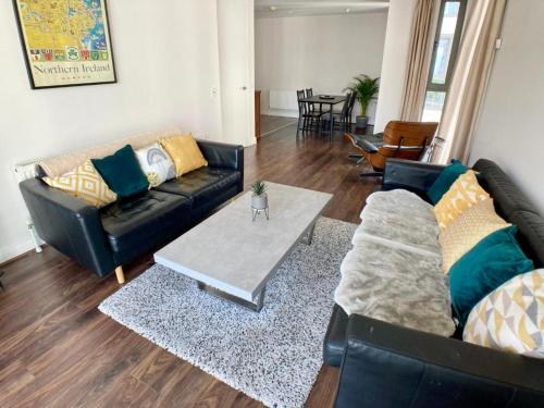 a living room with two couches and a table at Hamilton Road Apartments in Belfast