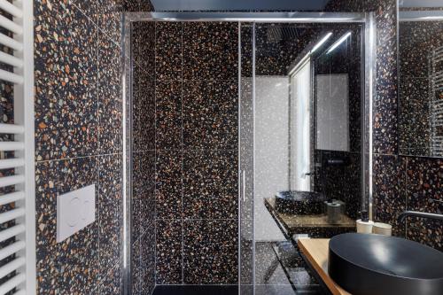a bathroom with a shower with a sink and a mirror at Residenza '900 in Castellanza