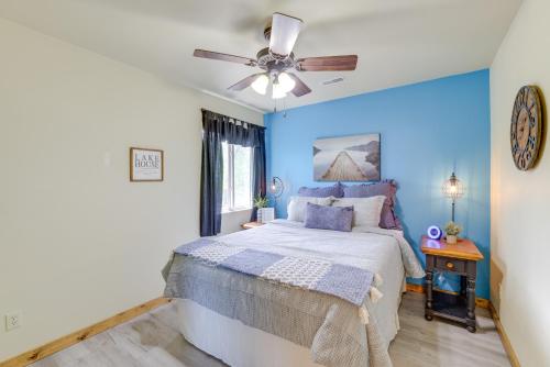 um quarto azul com uma cama e uma ventoinha de tecto em Lakefront Shell Knob Condo with Deck and Grill! em Shell Knob